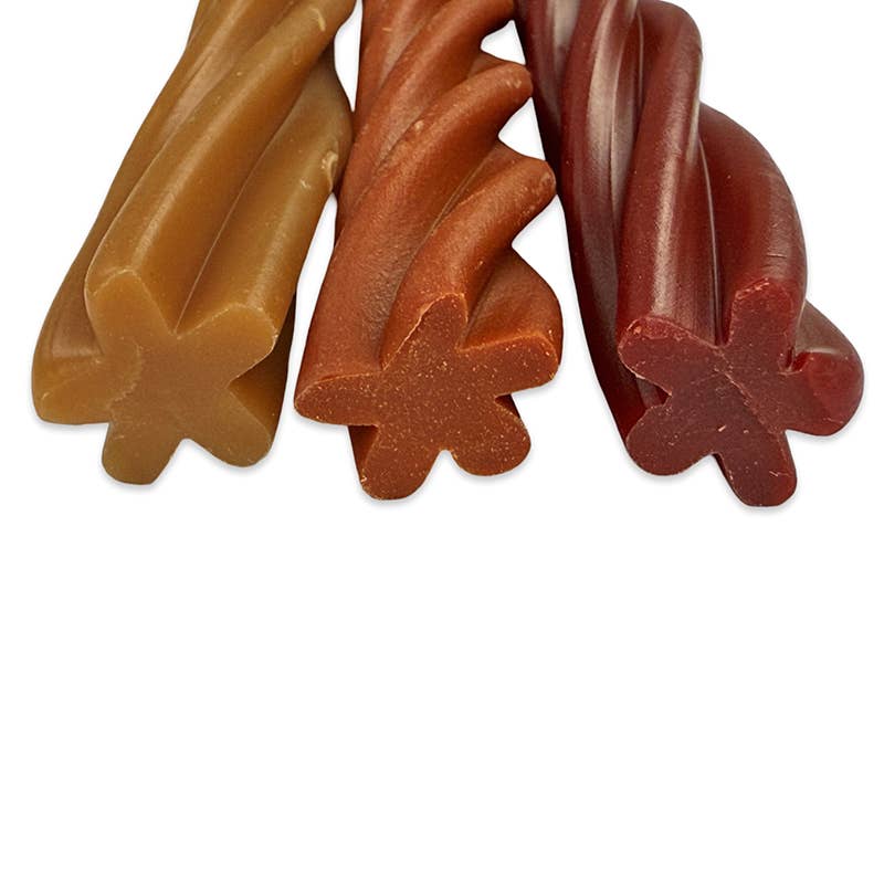 Three types of vegan dog chews in different colours on a white background
