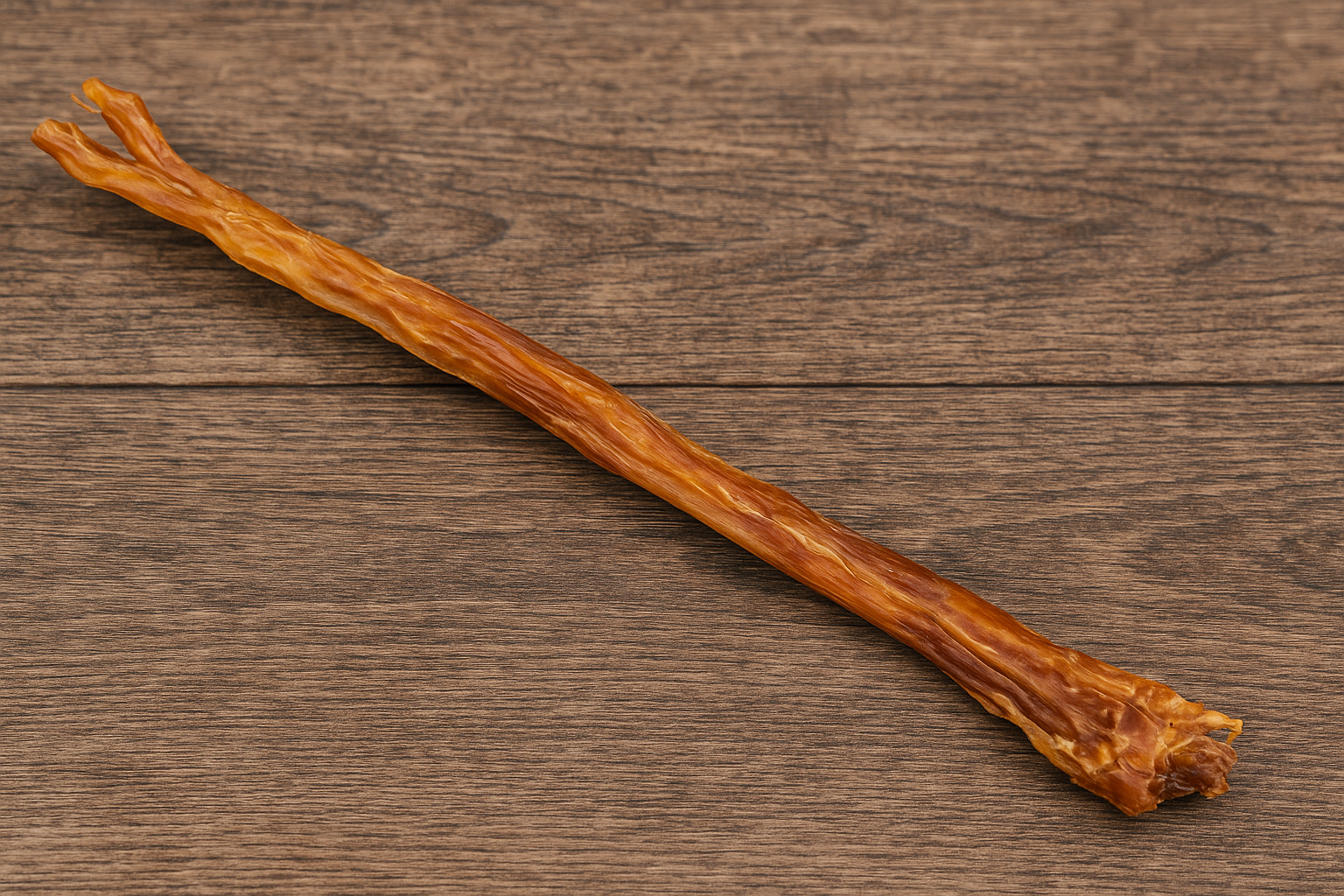 Close-up of natural Anco Ostrich Tendon dog chew showing texture and colour on rustic wooden background