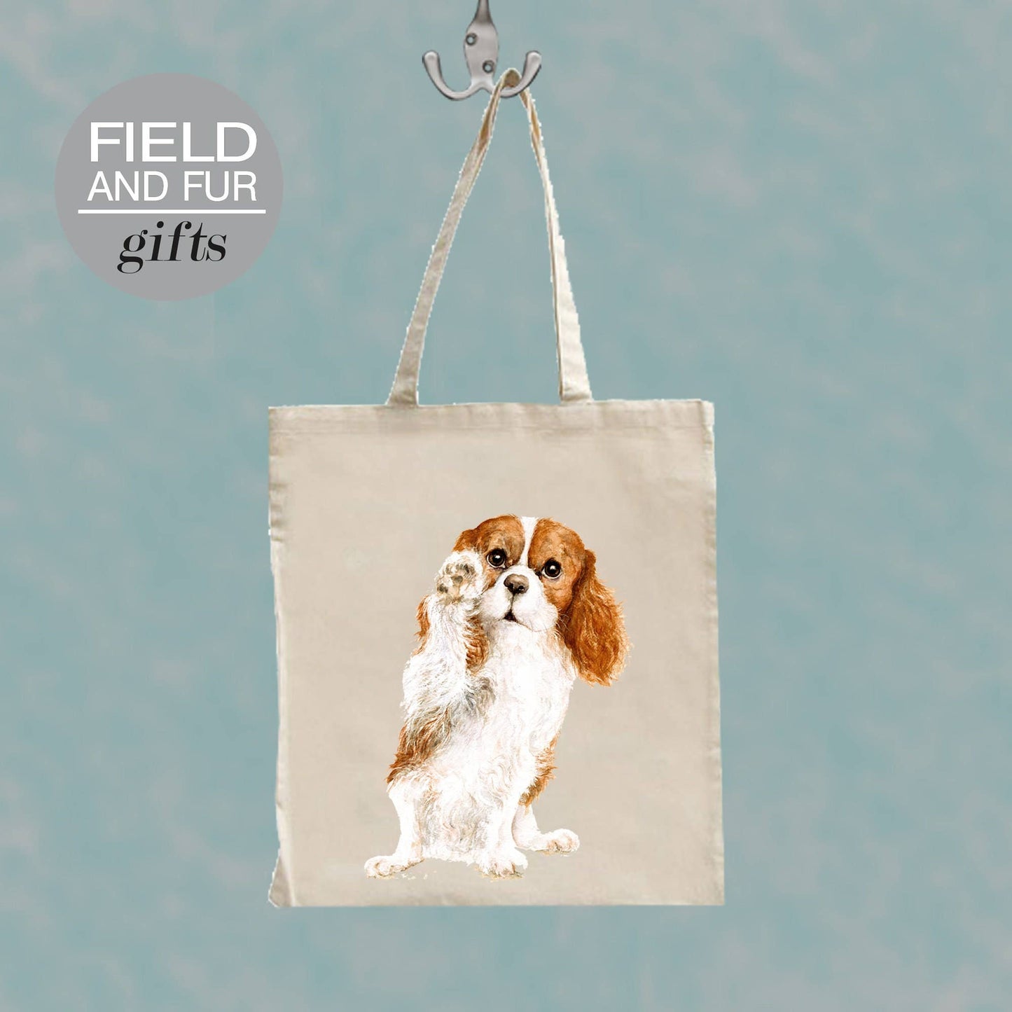 Cavalier King Charles tote bag featuring Jane Bannon’s Jenny artwork hanging on a hook – eco-friendly polyester shopping bag.