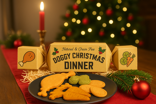 Festive Doggy Christmas Dinner Cracker displayed with grain-free dog biscuits shaped like roast dinner foods in a cosy Christmas setting with tree and decorations.