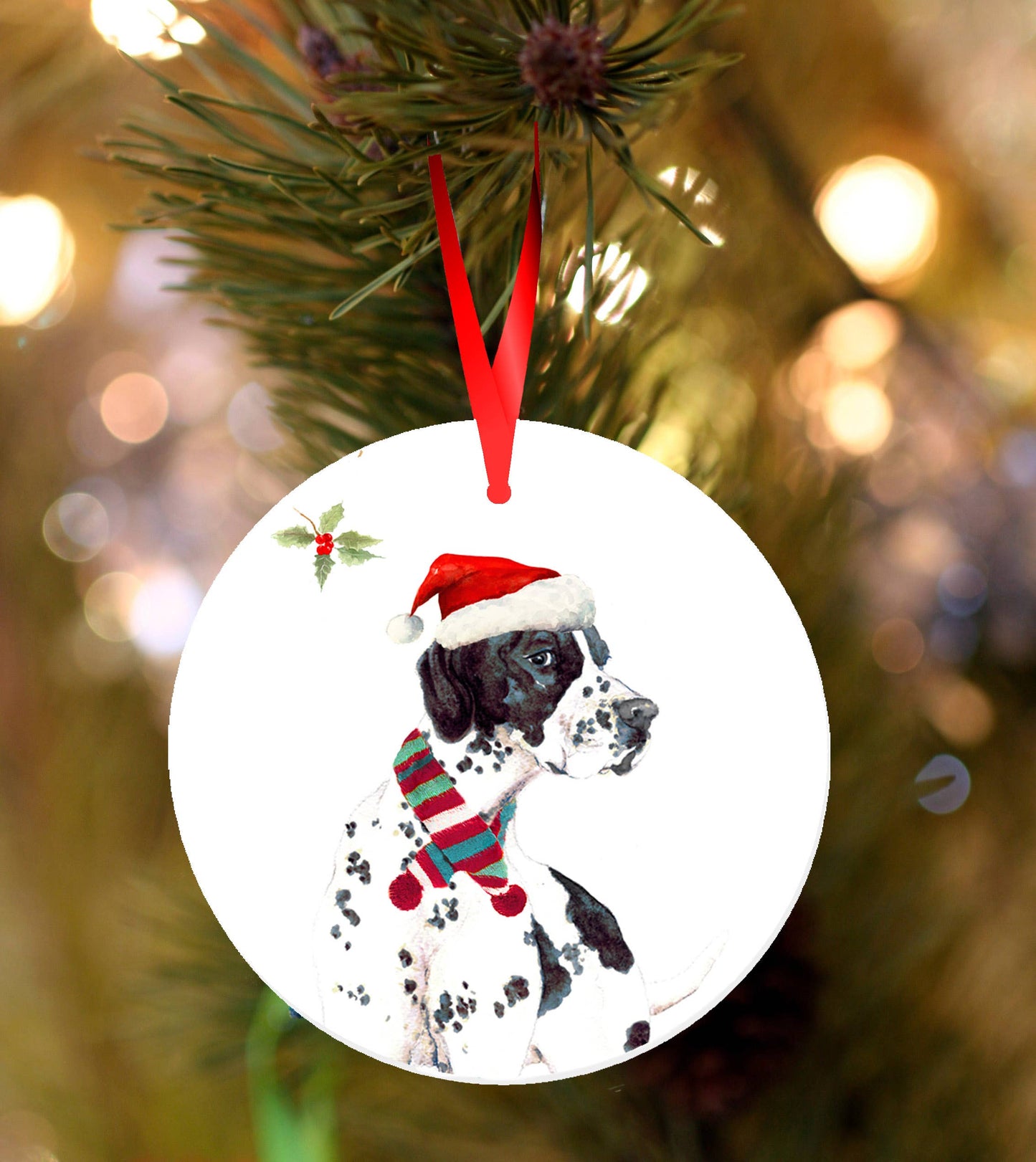 Ceramic Christmas ornament featuring a watercolour Pointer dog wearing a Santa hat and festive scarf, hanging from a red ribbon on a Christmas tree with warm blurred lights in the background.