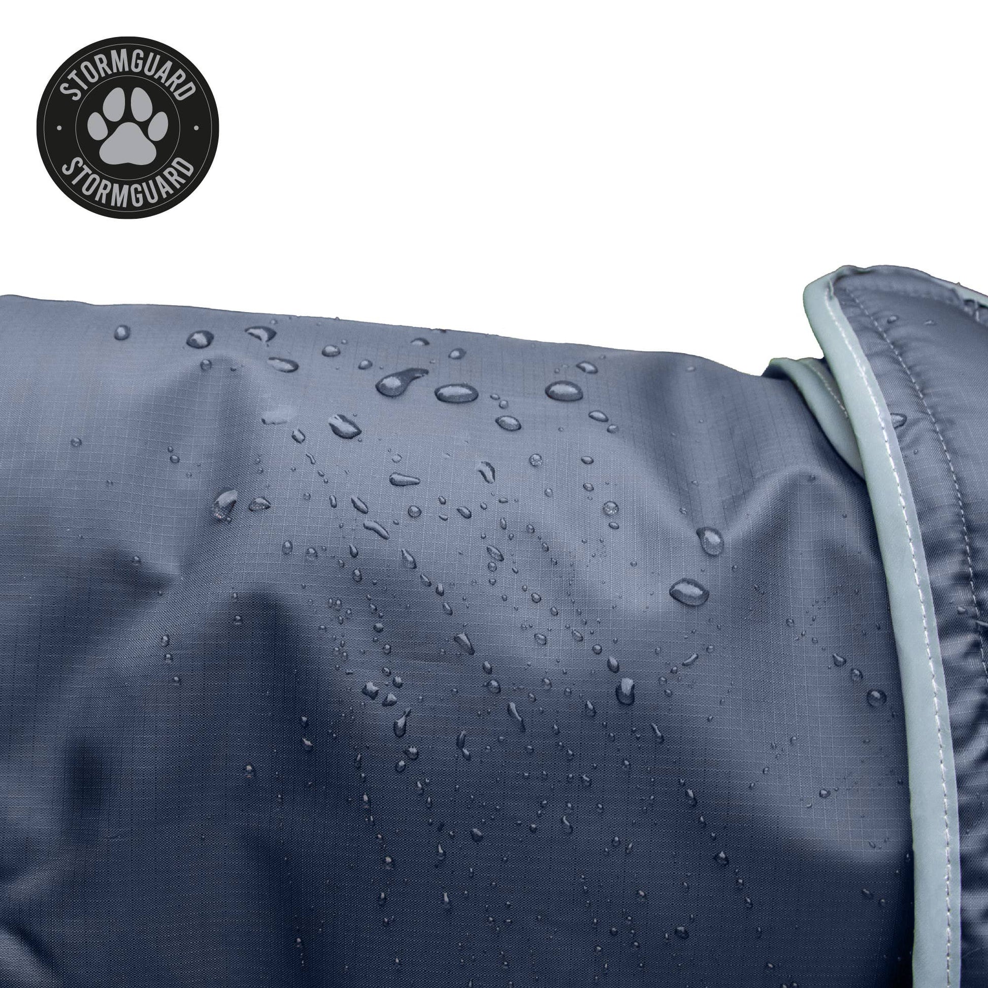Close up of Stormguard all weather dog coat showing waterproof navy fabric with water beading